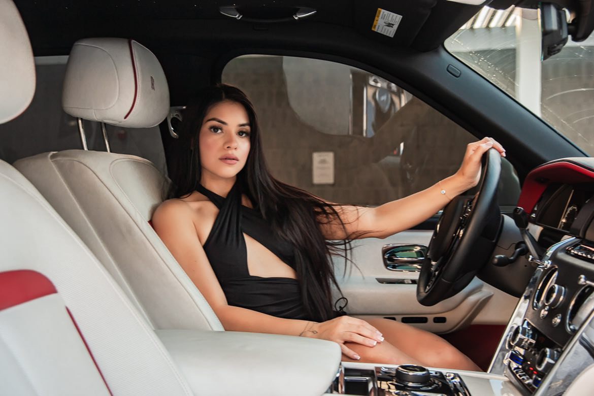 Woman at the wheel of a Leozen Rolls-Royce with white and red leather interior