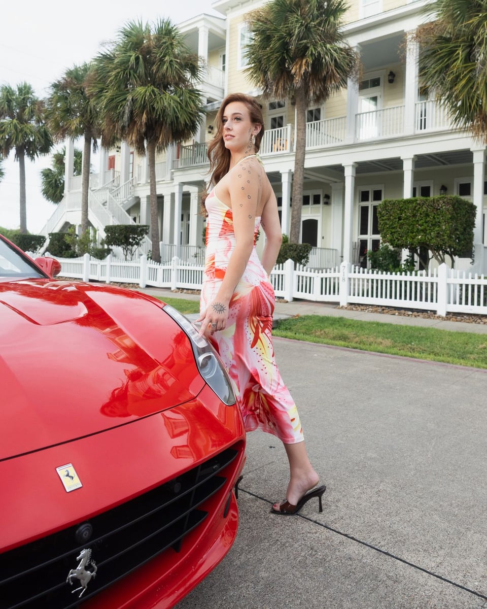 Red Ferrari California parked in front of a beach house lined with palm trees